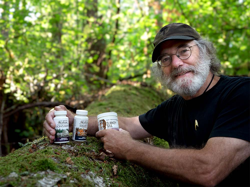 Paul Stamets holding Host Defense bottles