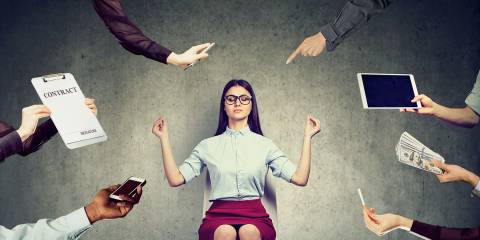 a woman meditating to reduce the stress of modern life and work