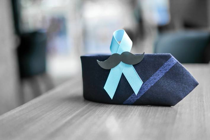 What Is Movember and No-Shave November? an awareness ribbon on a tie with a fake mustache