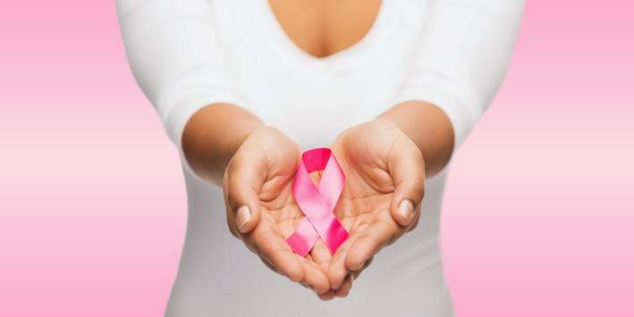 Foods that Protect Against Breast Cancer Woman holds breast cancer ribbon