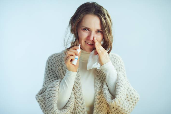 Clearing The Air: Nasal Hygiene a middle-aged woman with tissues and nasal spray