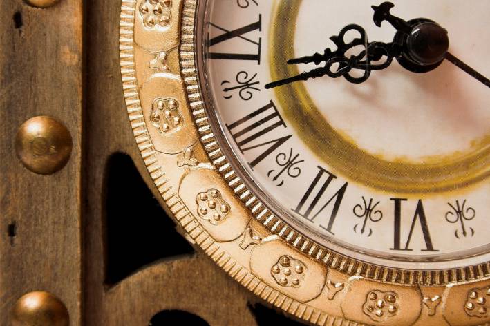 Improve Your Life with the Science of Timing Old wooden clock showing time, close-up.