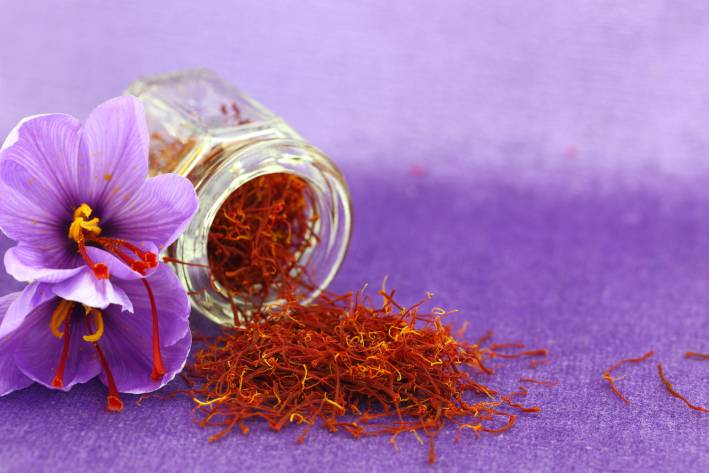 Saffron for Depression and Binge Eating A small jar of saffron next to a saffron flower
