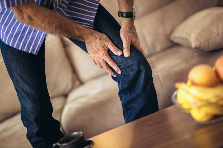 Natural Relief for Chronic Pain a middle-aged man grabbing his bad knee in pain