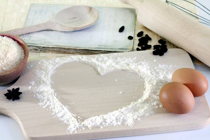 Feed Your Heart with Healthy Recipes cooking utensils, eggs, and flour on a cutting board in a heart design