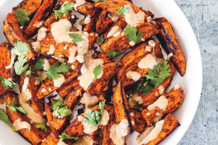 Roast Sweet Potatoes with Tahini Dressing sweet potatoes plated with tahini and cilantro