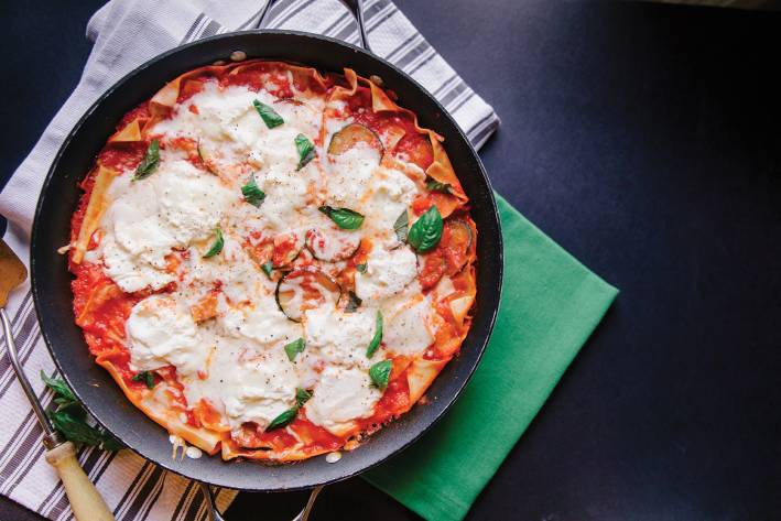 Veggie Skillet Lasagna Top view of Veggie Skillet Lasagna, ready to serve from skillet, on a black background.