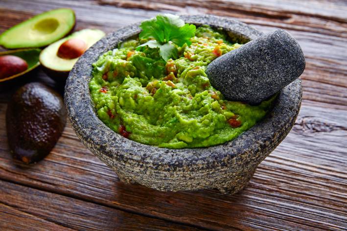 Guacamole guacamole sauce served in a traditional stone bowl