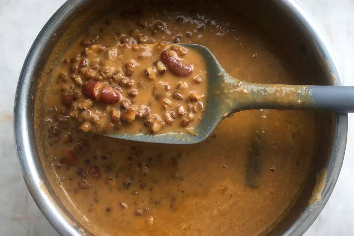 Dal Makhani stirring a pot of fresh dal with ghee
