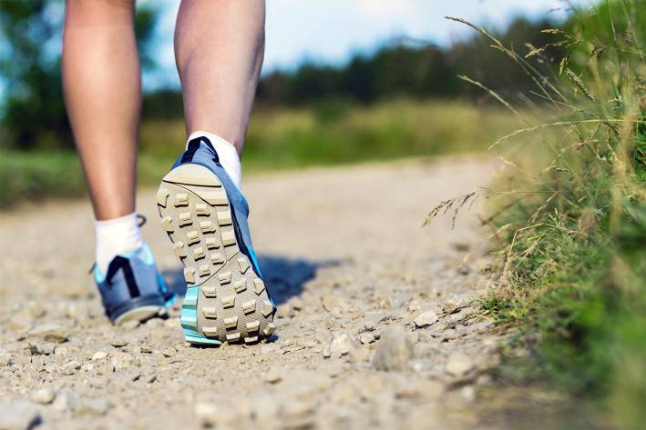 Sticking to Your Walking Program a man walking down a path near the forest