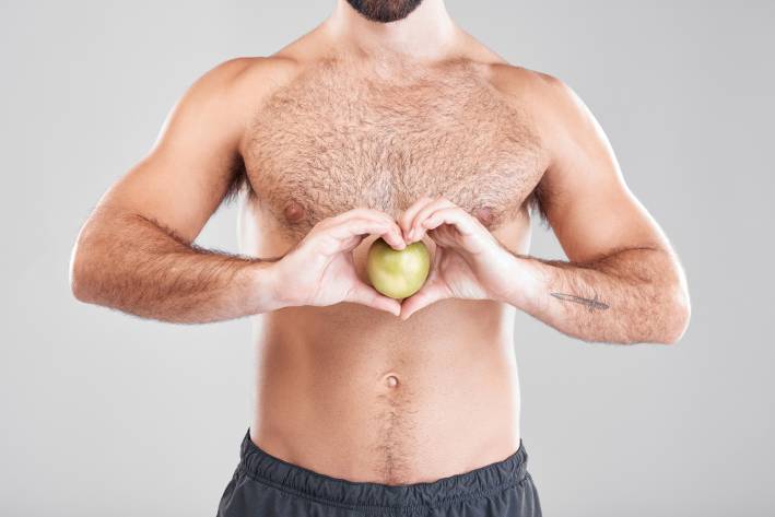 Healthy Gut, Healthy Men a healthy bare-chested man holding an apple