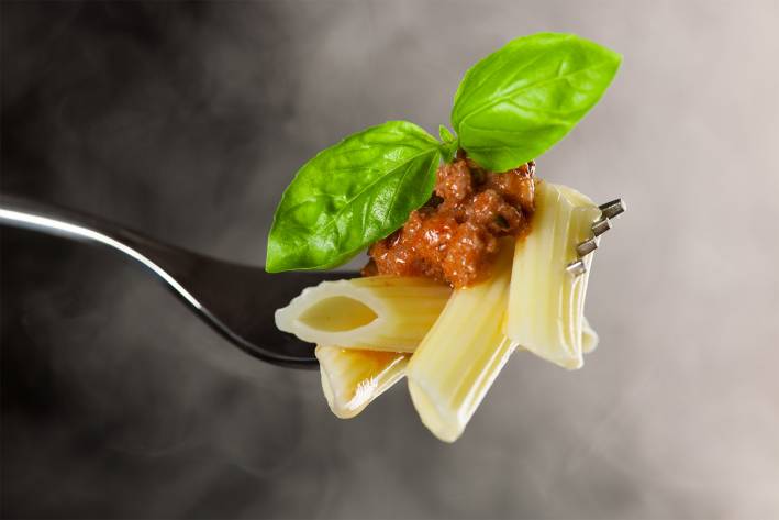 How to Make Great Pasta Perfectly cooked penne on a fork with rolling steam